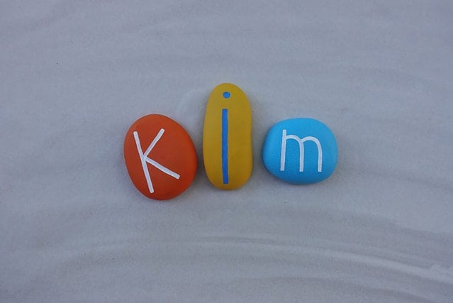 Kim, given name composed with colored stones over white sand