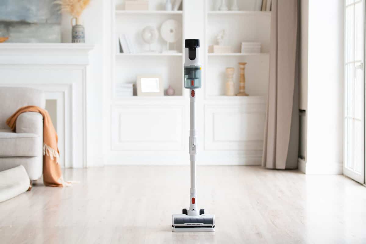 Close-up of wireless modern vacuum cleaner in light interior. House cleaning.