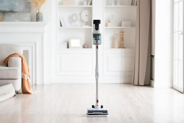 Close-up of wireless modern vacuum cleaner in light interior. House cleaning.