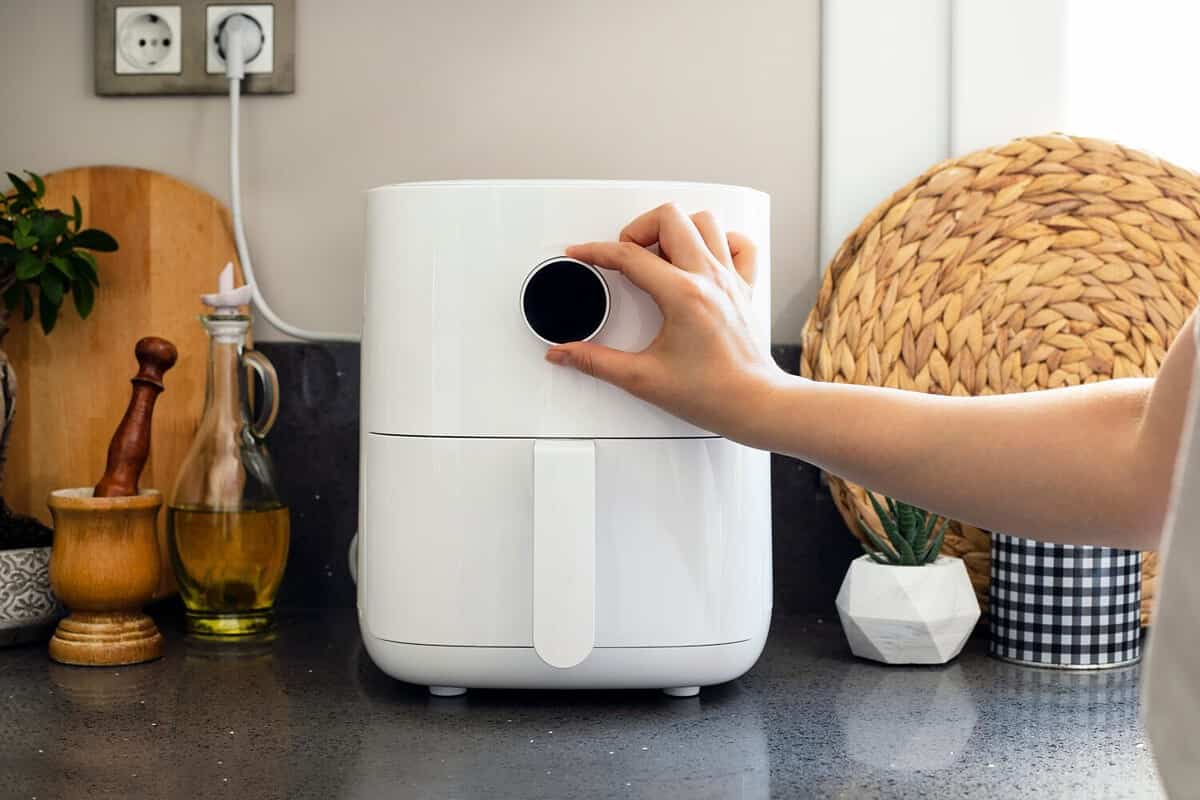 Woman cooking with modern Air fryer