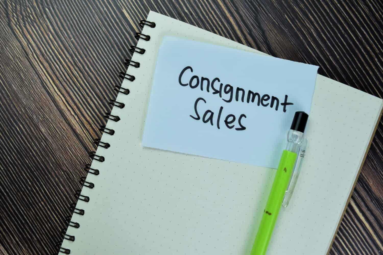 Concept of Consignment Sales write on sticky notes isolated on Wooden Table.