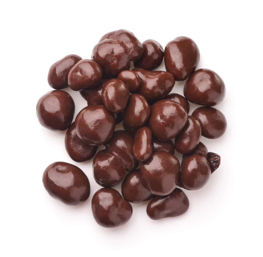 Top view of dark chocolate covered raisins isolated on white