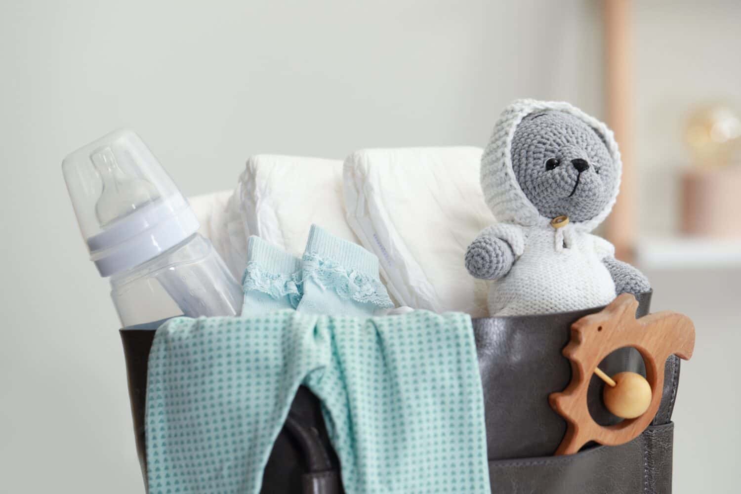 Mother's bag with baby's stuff indoors, closeup