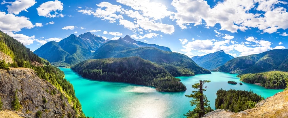 Panorama of a bright blue lake in North Cascades National Park.