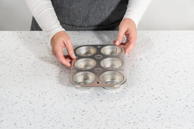 Empty a small muffin pan on a kitchen counter.