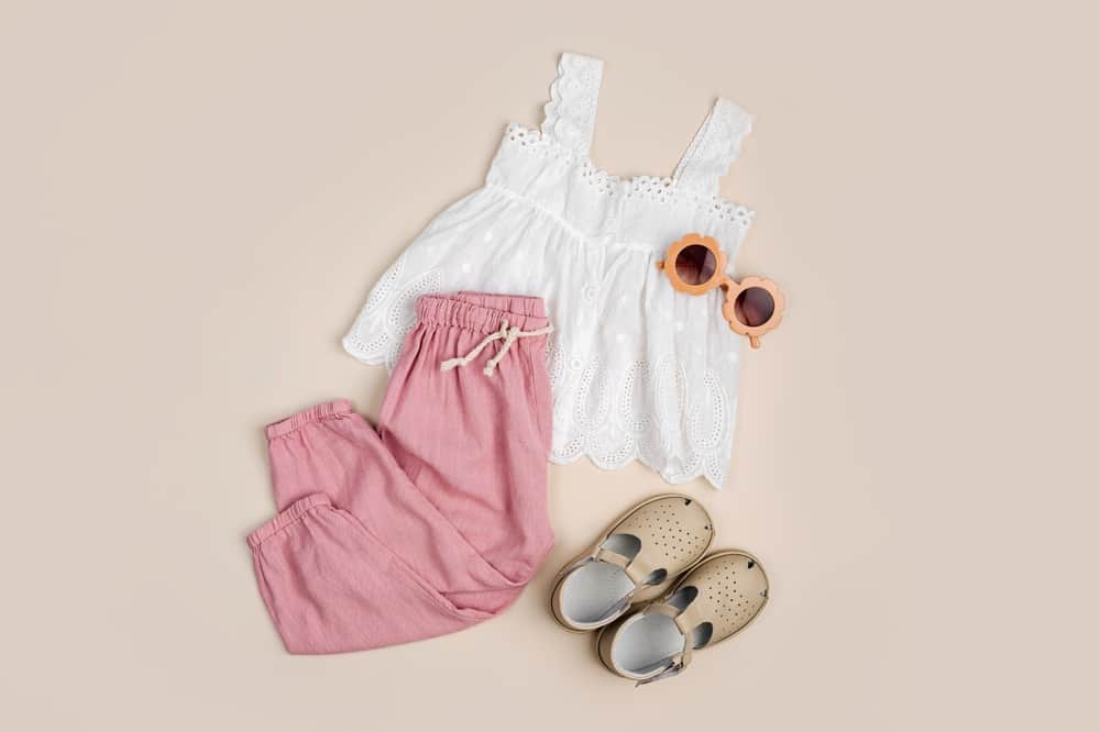 Cotton blouse with trousers. Stylish baby clothes and accessories for summer. Fashion kids outfit. Flat lay, top view