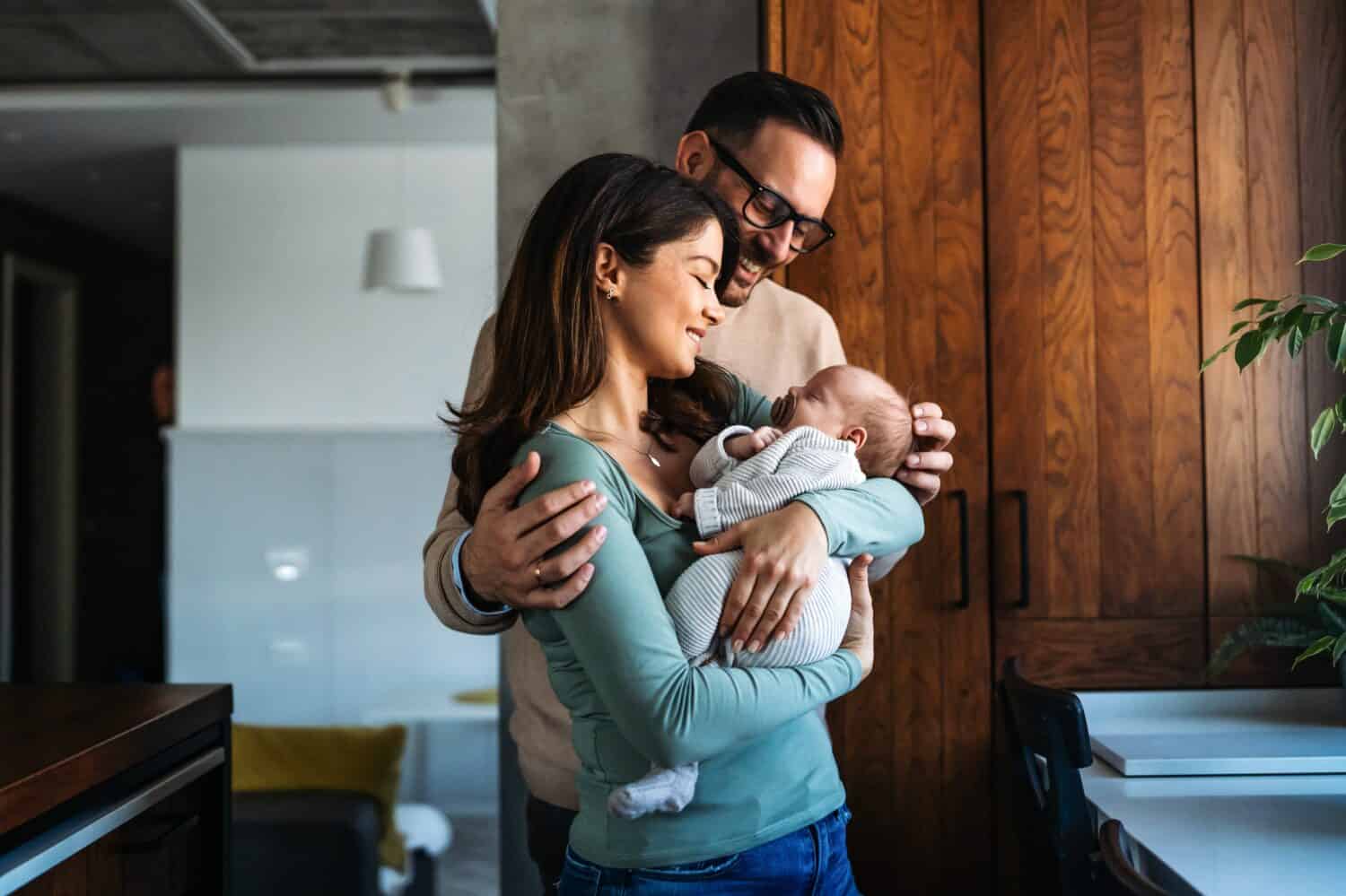 Family, parenthood and people concept. Happy young mother, father with new born baby at home