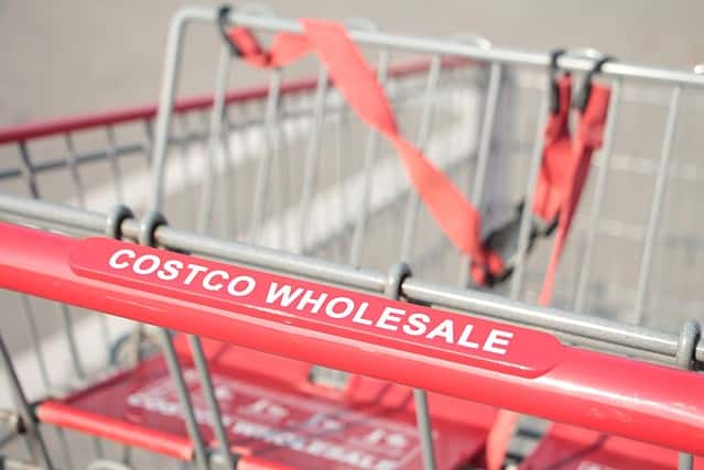 costco wholesale red silver shopping cart close up on costco wholesale writing caption text on handle close up in summer shot on angle