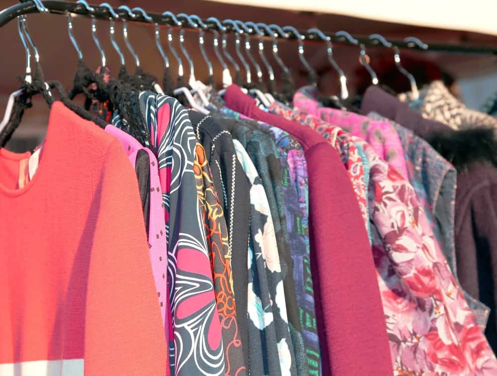 Many vintage style clothes and retro for sale at an outdoor flea market