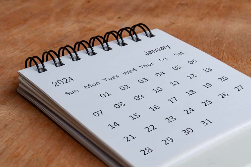 January 2024 white table calendar on wooden background. Calendar concept.