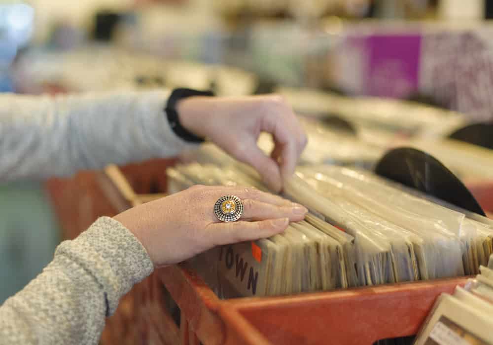 Close up on woman's hands browsing record store