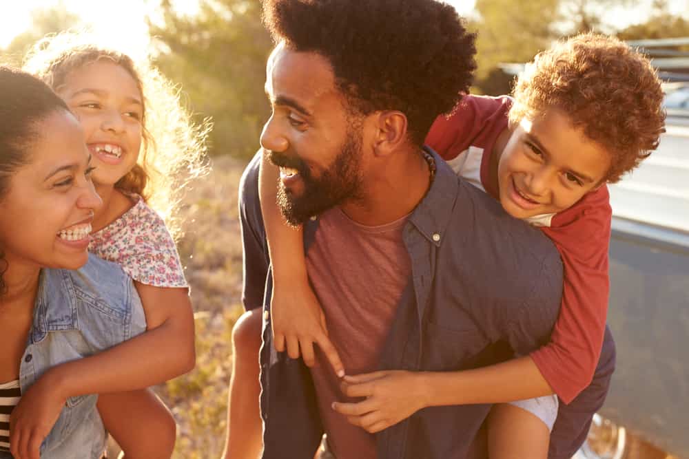 Parents giving their kids piggybacks, waist up, close up