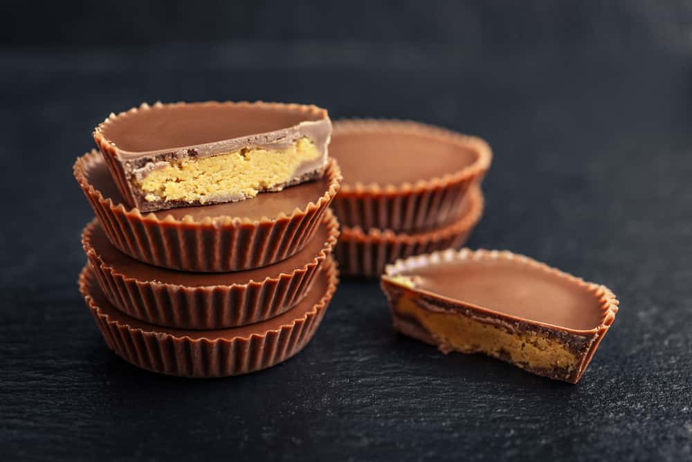 Peanut butter cups, chocolate dessert on black background closeup