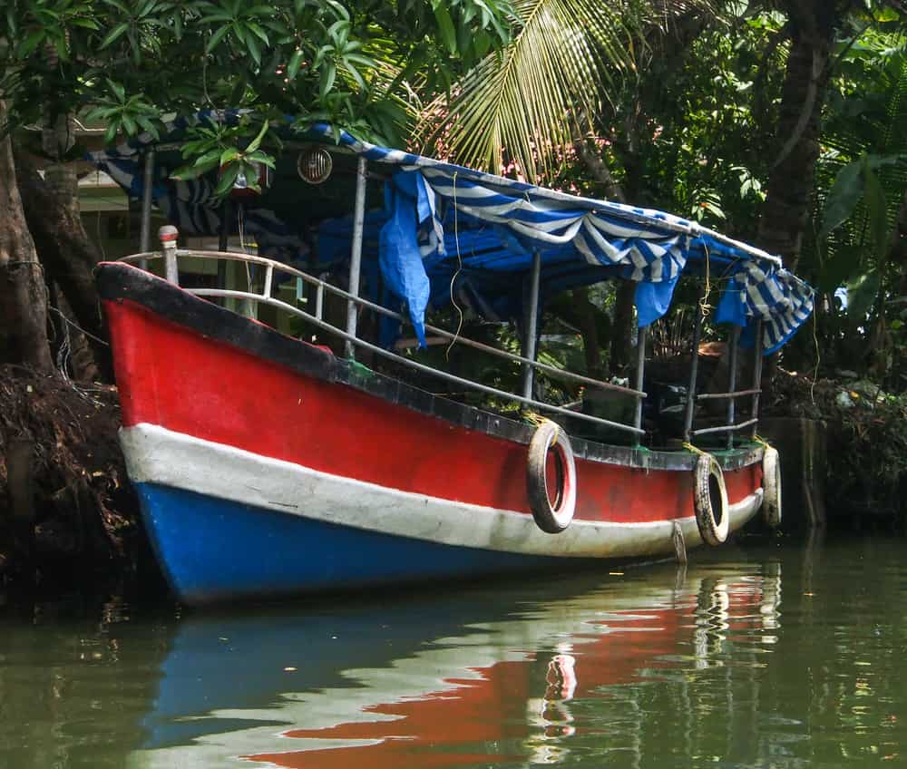 Colurful boat on a smal canal in the backwaters of Kerala
