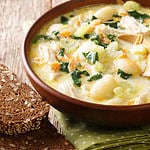 cream soup with gnocchi, chicken and spinach served with bread close-up in a bowl on the table. Horizontal