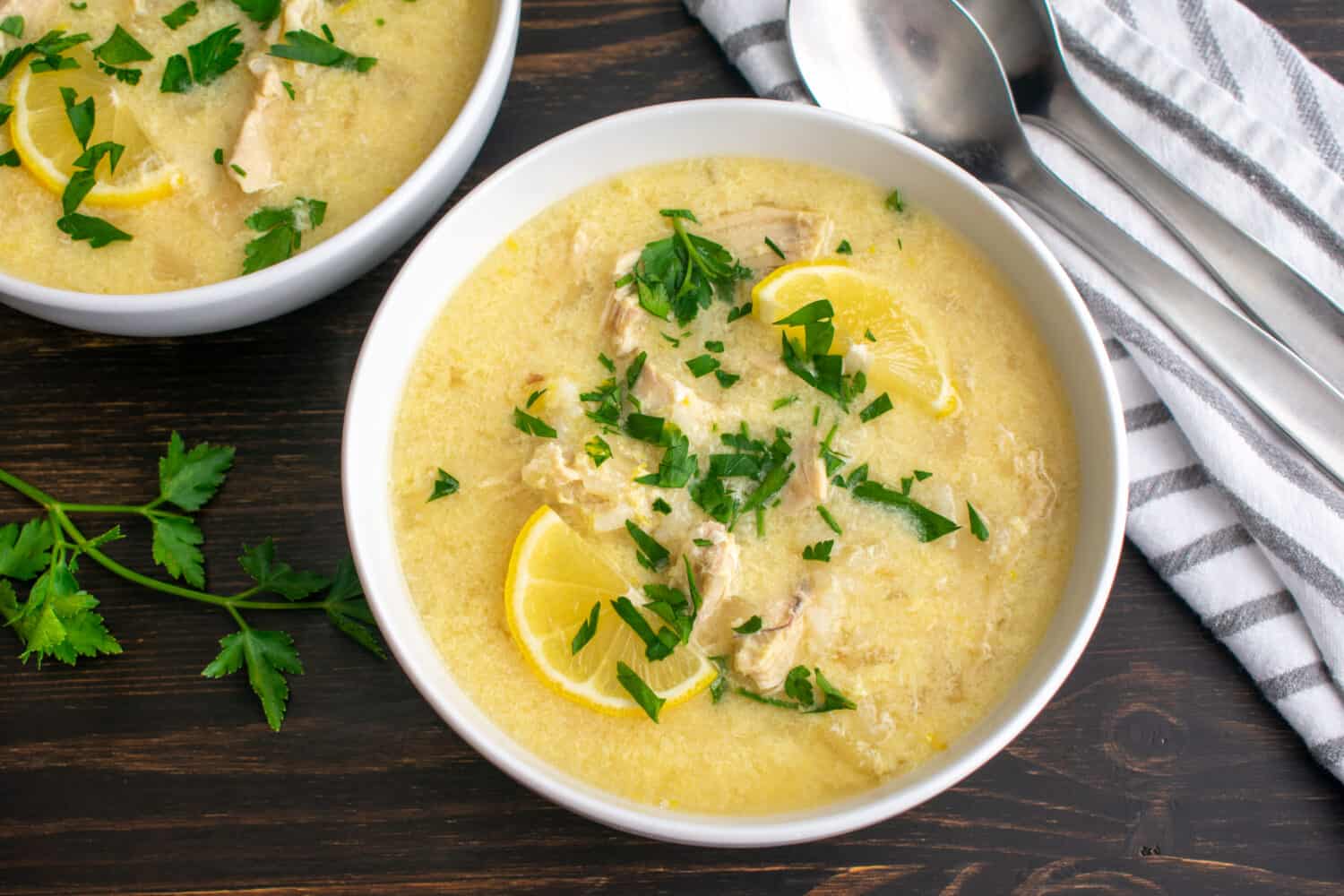 Avgolemono Soup (aka Greek Lemon Chicken Soup): Bowls of traditional Greek soup made with chicken, rice, and lemons