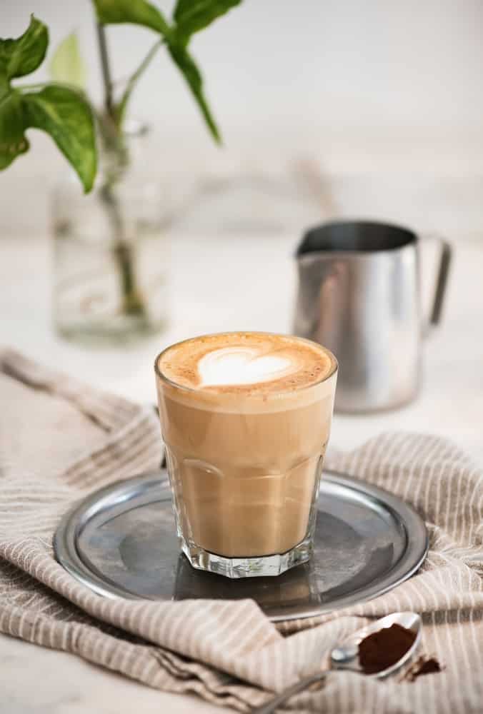 Flat white coffee with heart shaped milk and coffee powder