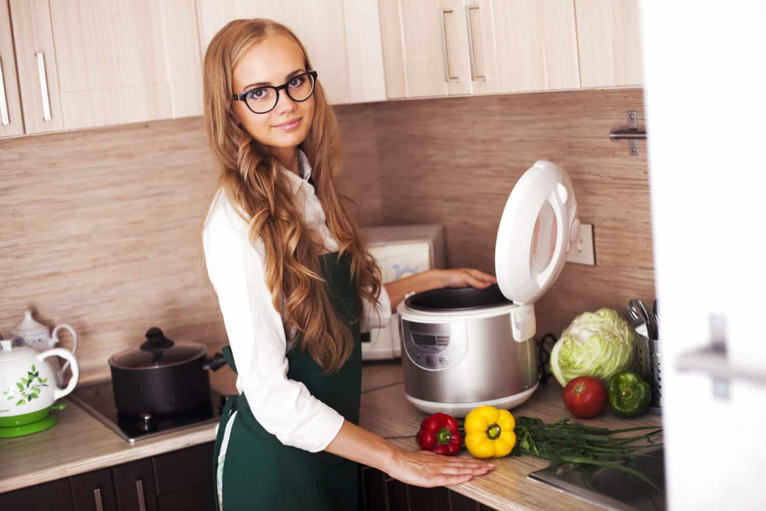 beautiful girl in the kitchen with crockpot slo-cooker