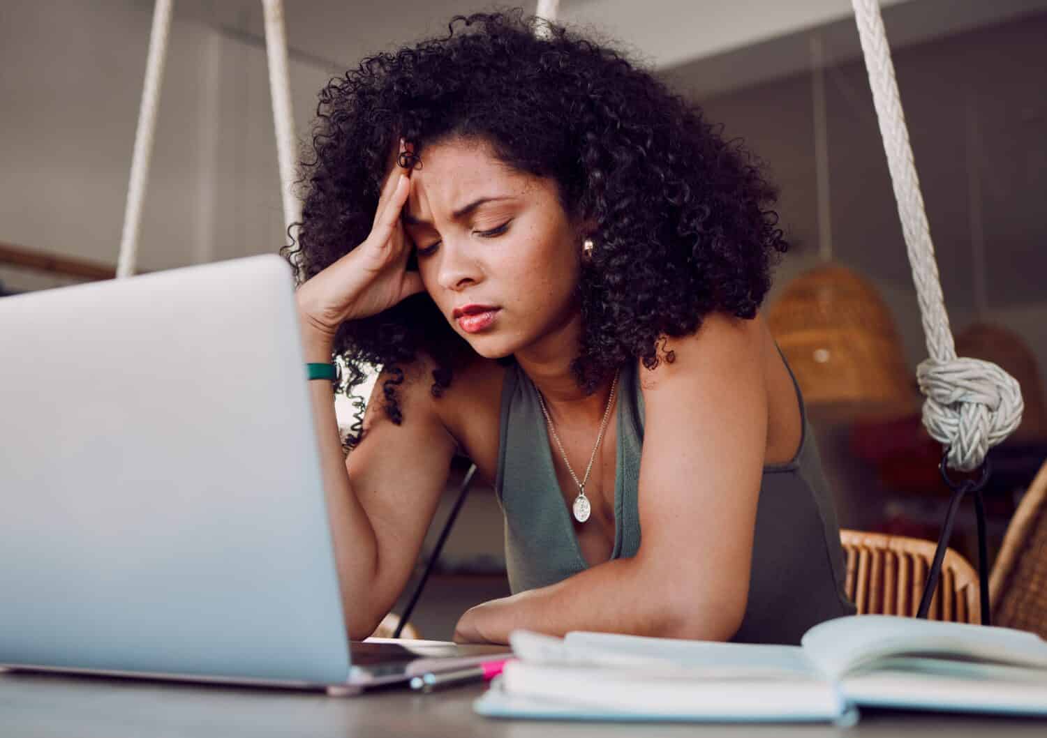 Stress, student and black woman with laptop in cafe frustrated from studying, working and project. University, burnout and stressed girl in coffee shop tired from learning on computer and books