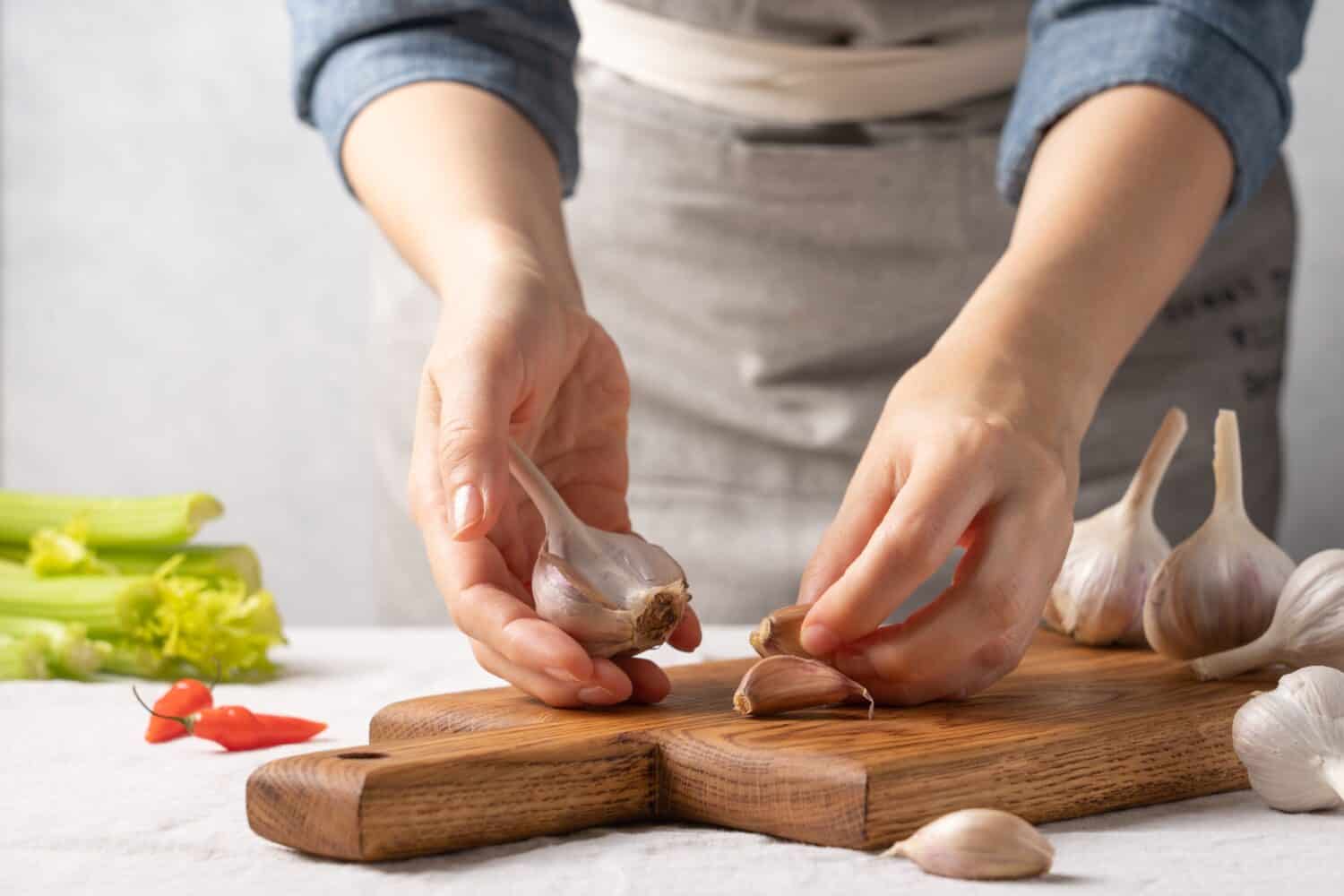 Women's hands holding garlic. Cooking homemade healthy food
