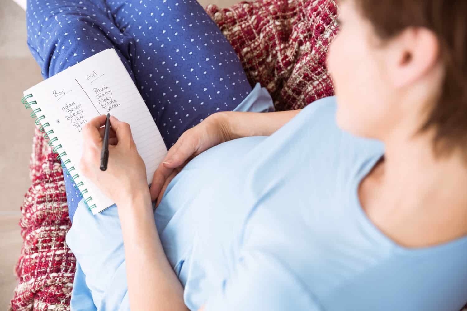 Pregnant woman looking at ultrasound scans at home in the living room