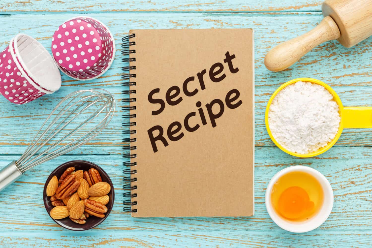 Baking secret recipe book with baking ingredients on wood table