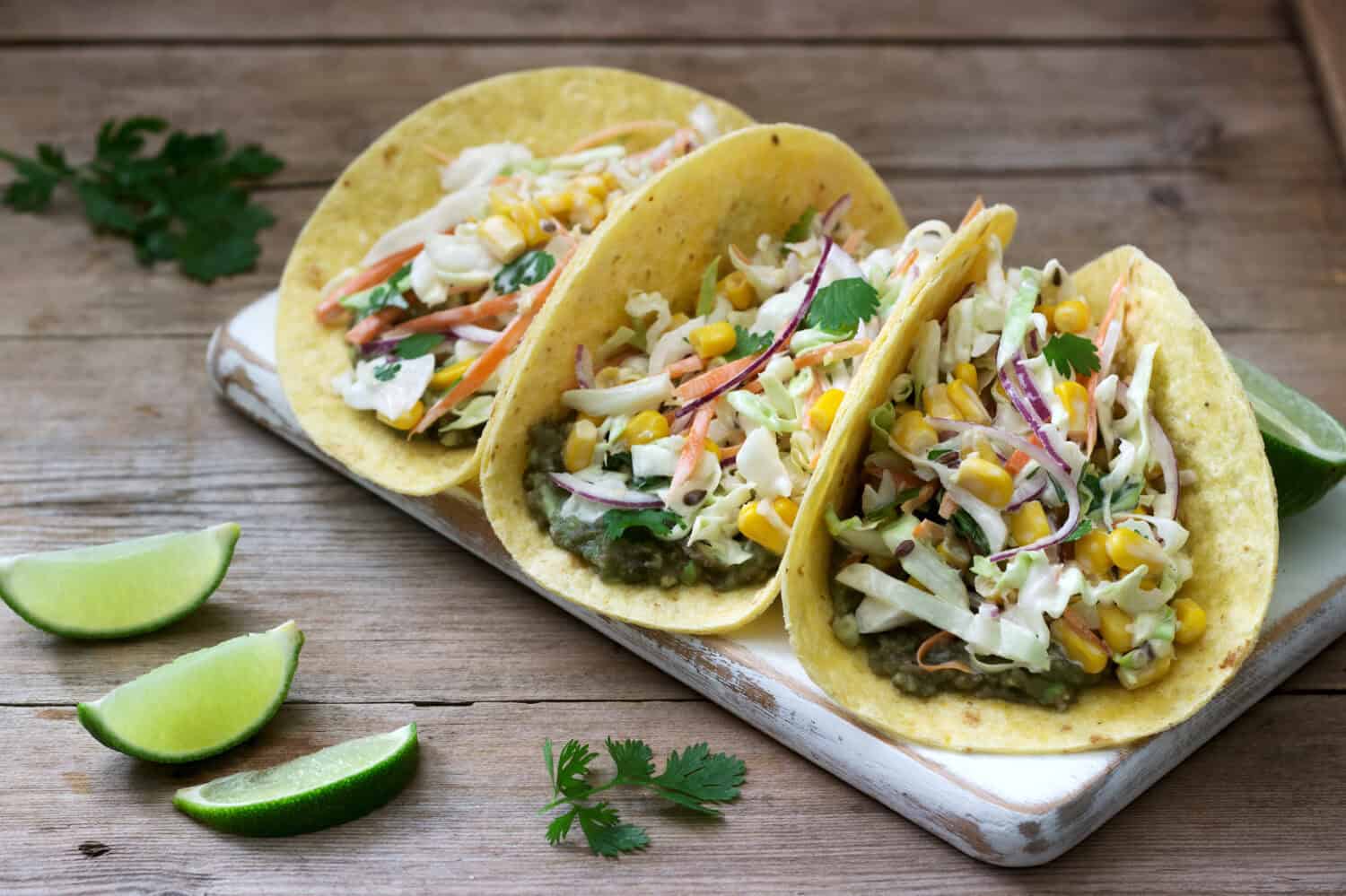 Vegetarian tacos stuffed with cabbage salad on a wooden background. Rustic style.