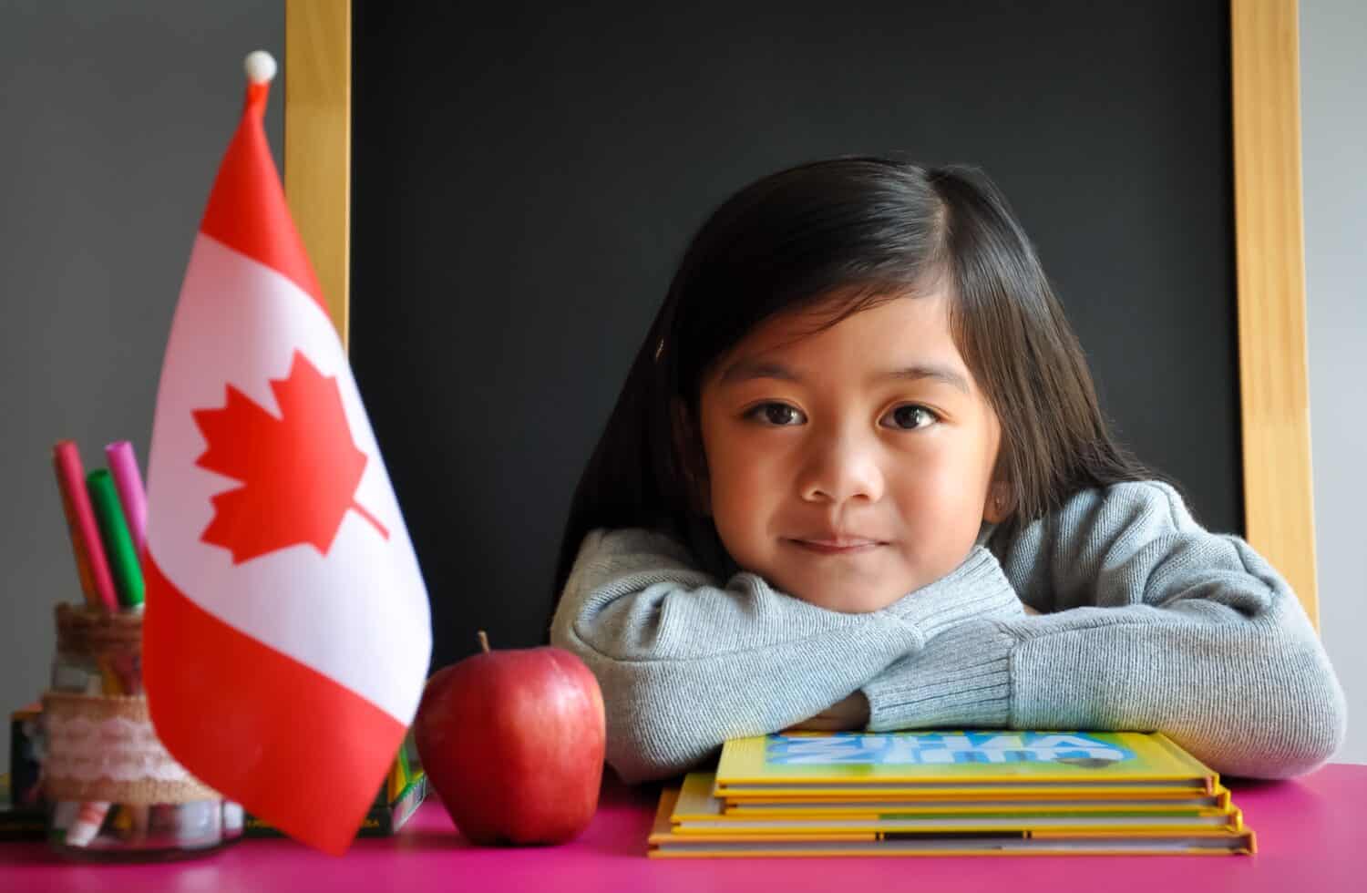 Beautiful Canadian girl sitting behind her school desk