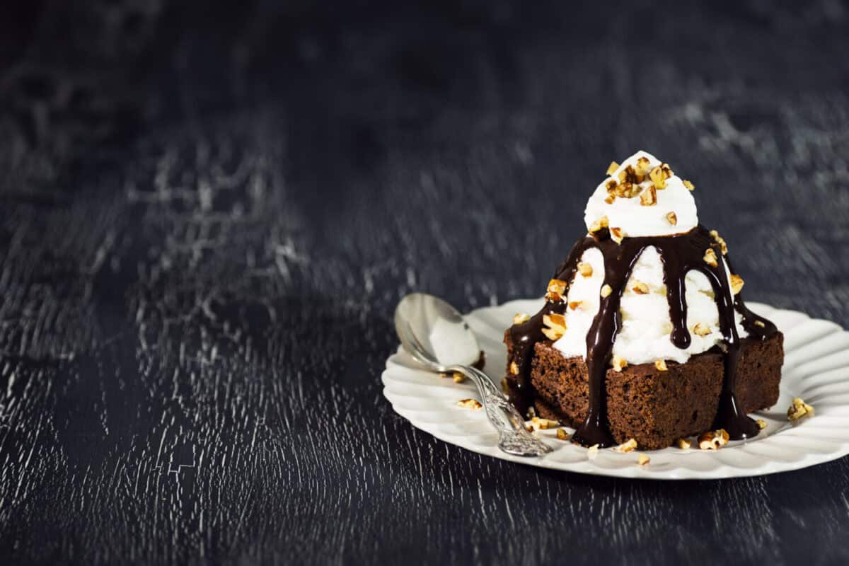 Brownie Sundae with a Scoop of Vanilla Ice Cream, Chocolate Sauce, Whipped Cream, and Nuts with Copy Space