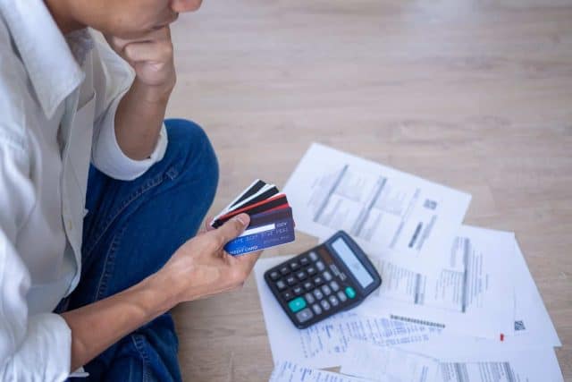 Man sitting stressed out with home expenses and monthly credit card debt.