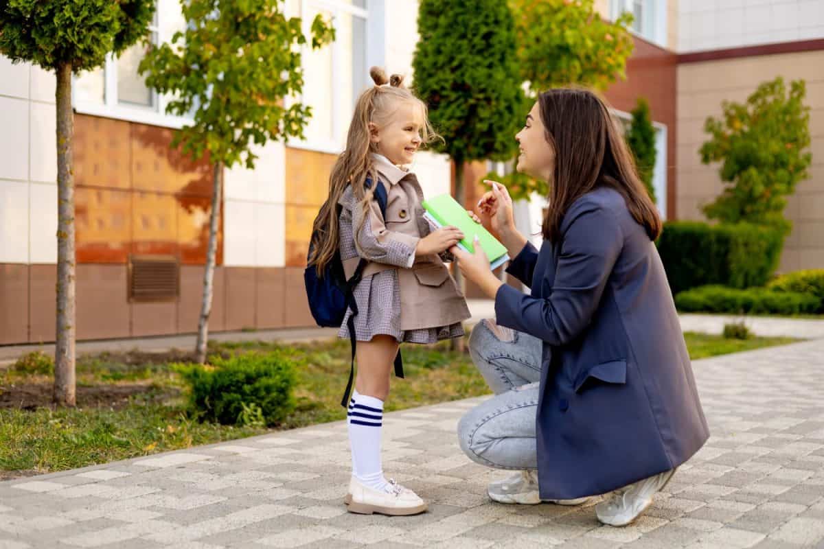 mom accompanies her first-grader daughter to school, kissing her and hugging her, back to school, the parent gives the child to the first grade. Mom meets a student from school.