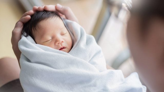 Portrait of young asian father or mother with healthy newborn baby, copy space with bed in hospital background. Single caucasian dad, happy family healthcare and father's day concept top view banner