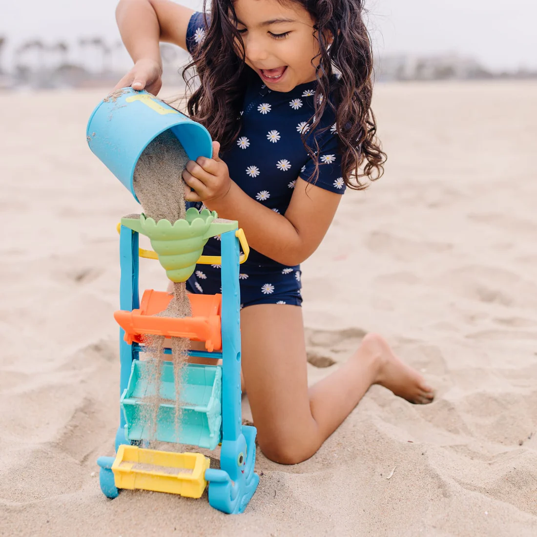 kid playing with Melissa & Doug toy on the beach