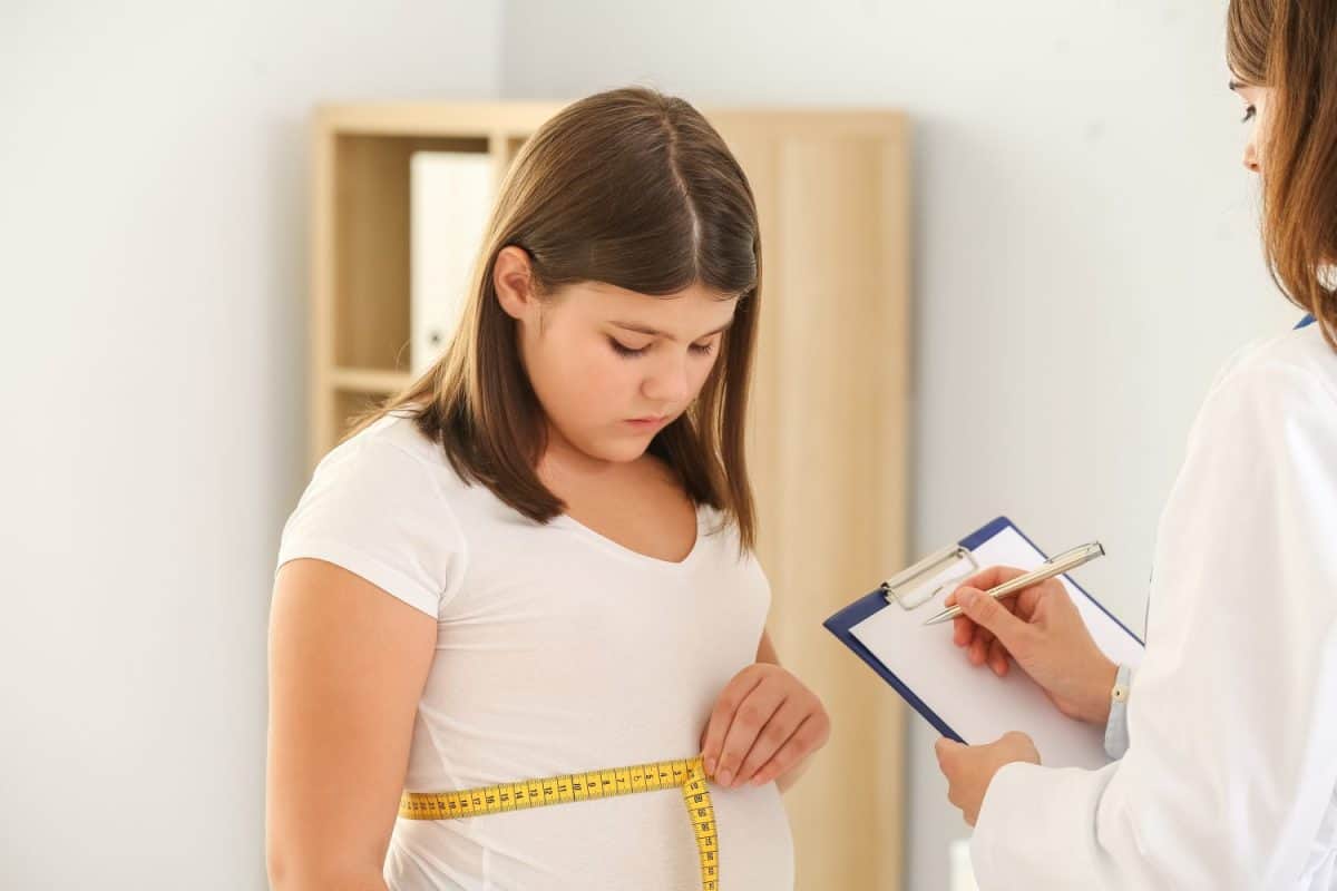 Overweight girl visiting nutritionist in clinic