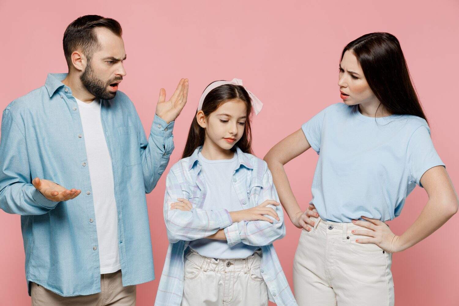 Young strict sad angry indingnant parents mom dad with child kid daughter teen girl in blue clothes scold kid isolated on plain pastel light pink background. Family day parenthood childhood concept