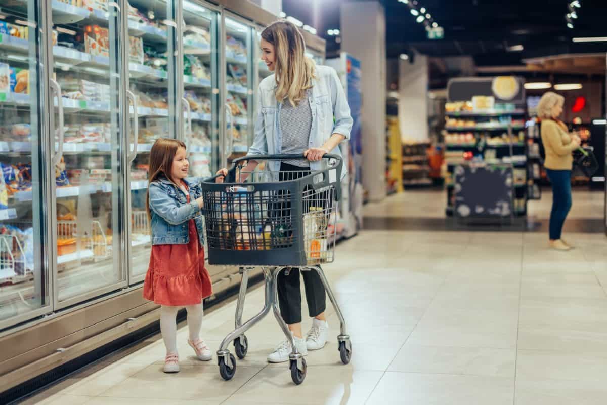 Mom and her little daughter are in a grocery store shopping for food