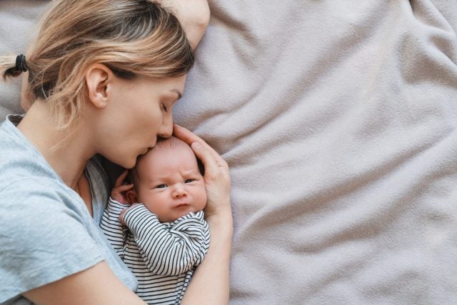 Mother and baby. Loving mom spending time with her little 2 weeks old child at home. Image of bonding mother and baby, healthy physical and mental development of child, happy maternity and family.