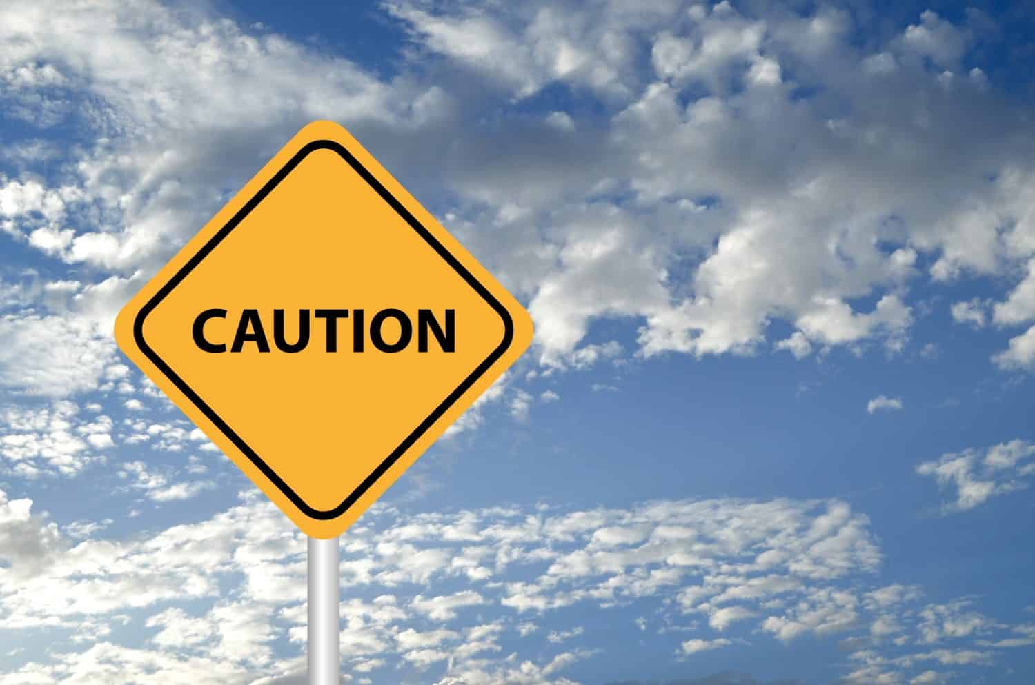 caution yellow sign on sky background