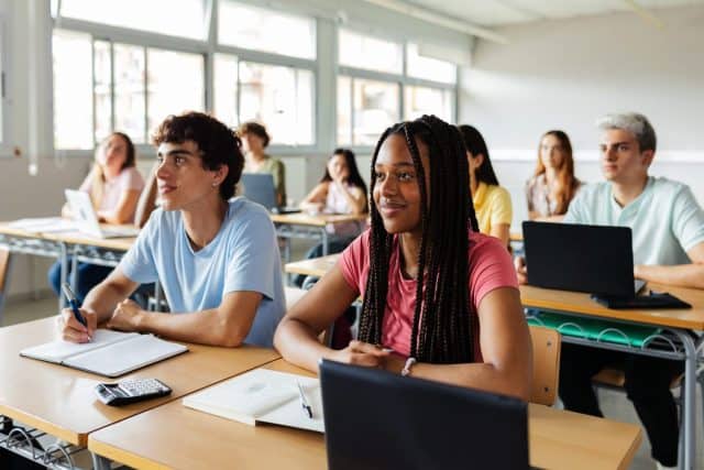 Diverse young high school students listening to teacher in classroom. Education lifestyle and lecture concept