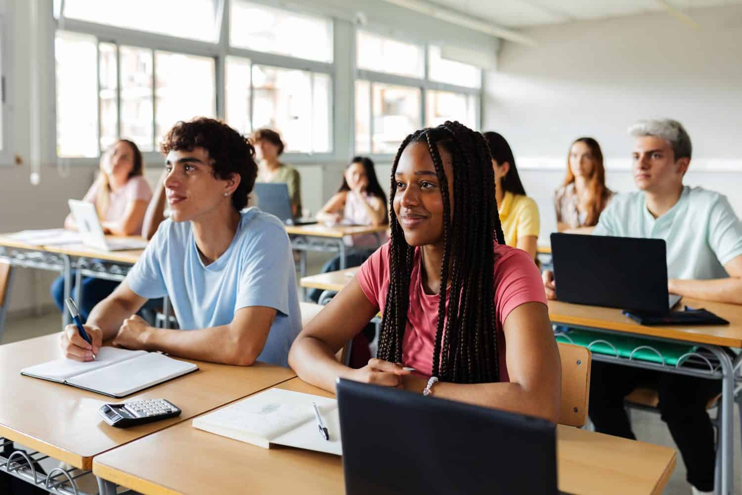 Diverse young high school students listening to teacher in classroom. Education lifestyle and lecture concept