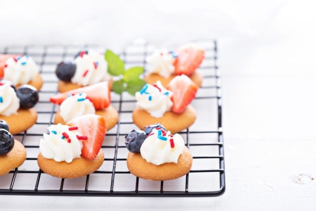 Little desserts with whipped cream, sprinkles and berries