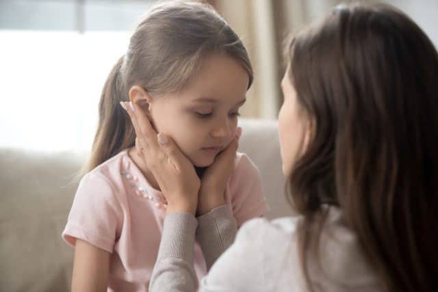 Loving young mother touching upset little daughter face, expressing support, young mum comforting offended adorable preschool girl, showing love and care, child psychologist concept, close up