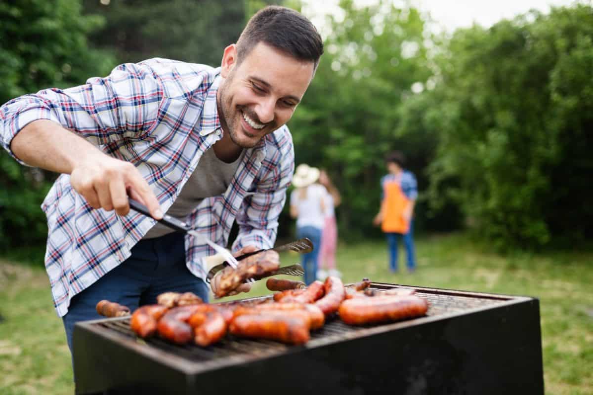 Happy friends camping and having a barbecue in nature