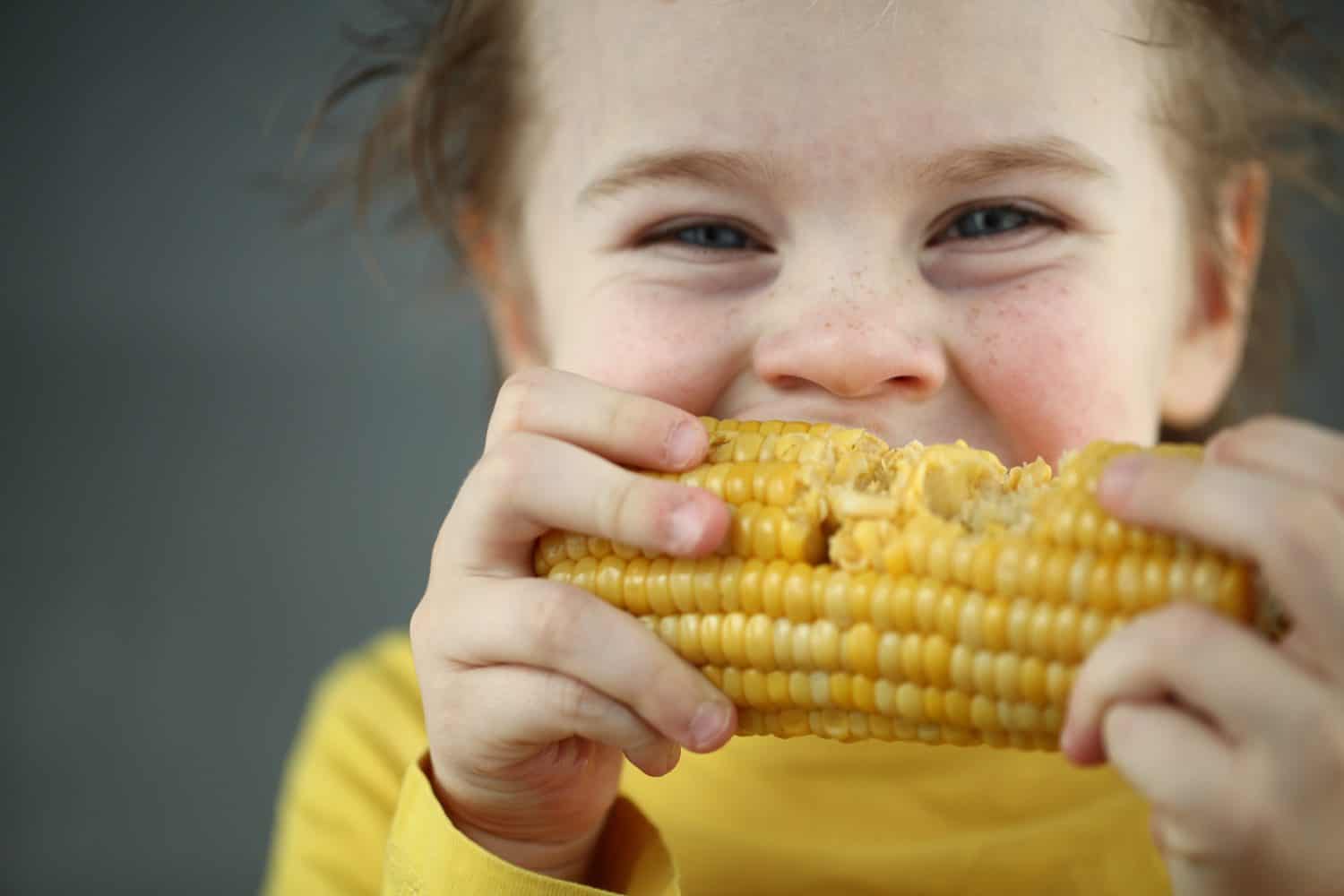 Boy eating sweet corn