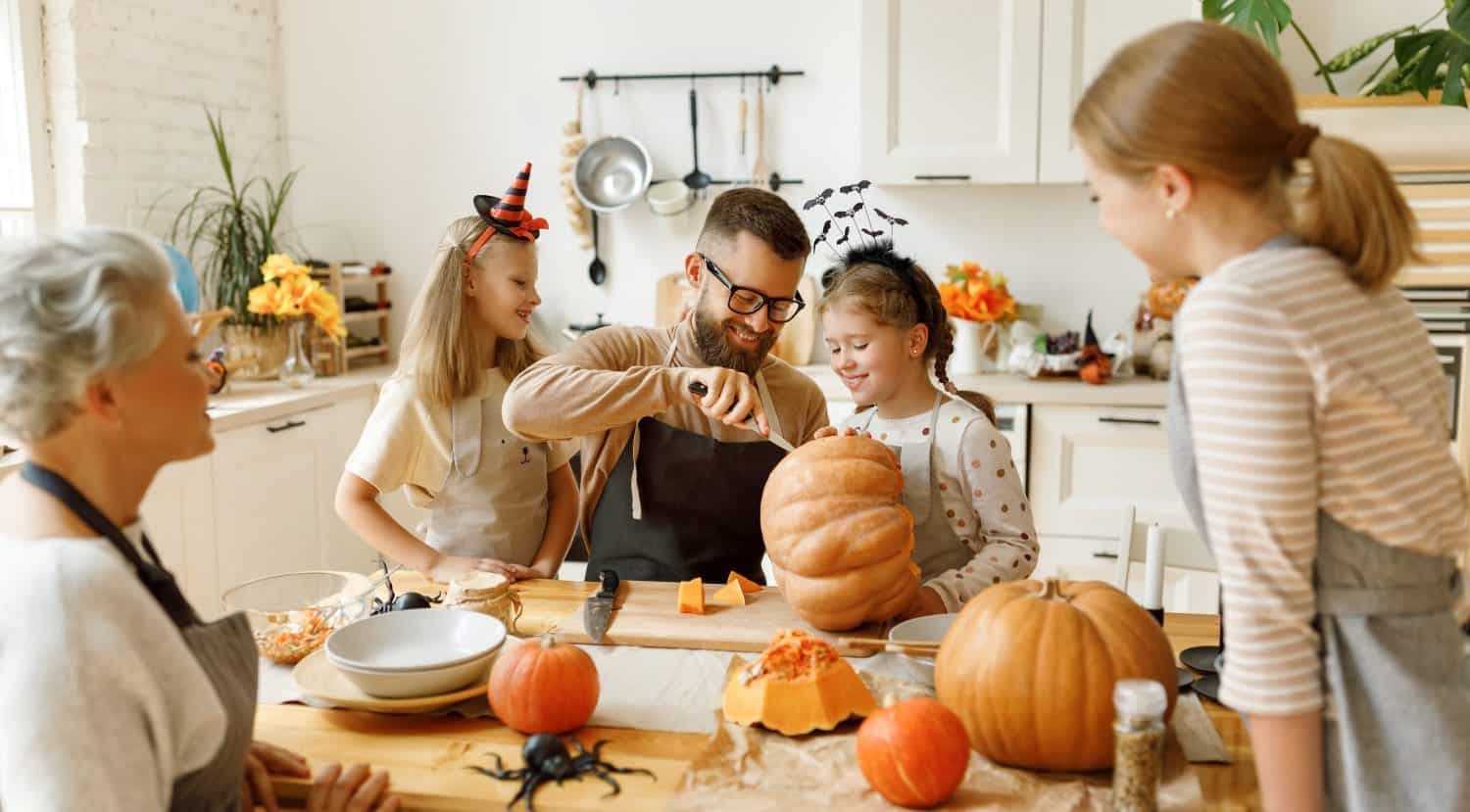 Happy Family Sitting With Pumpkins At Home Stock Photo