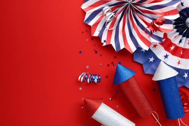 Independence Day USA banner mockup with US flag color paper fans and firework rockets on red background. USA Presidents Day, American Labor day, US election concept.