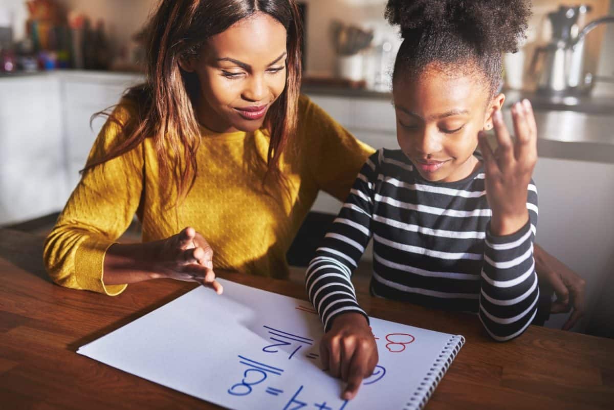 Mother and daughter doing homework learning to calculate