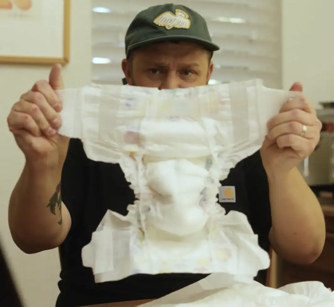 Brady Crandall, co-founder of Youth Crews, holding up a youth diaper