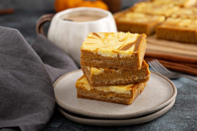 Pumpkin pie bars layered with swirls of cheesecake, fall dessert recipe