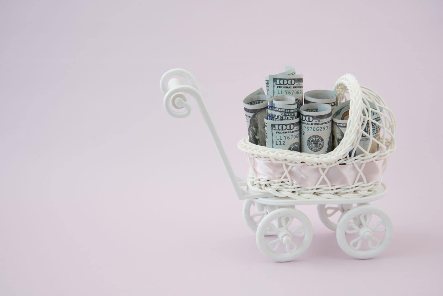 In the stroller for newborns are American dollars. The concept of assistance to families with children, benefits for pregnancy and childbirth. Expenses for a newborn baby. Surrogacy.